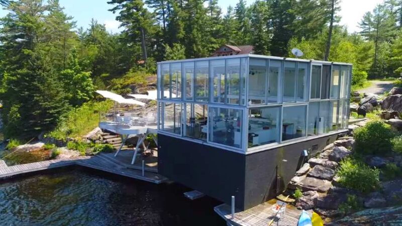 Fotografův dům se skleněnou podlahou s otevřenou podlahou stojí nad kanadským jezerem